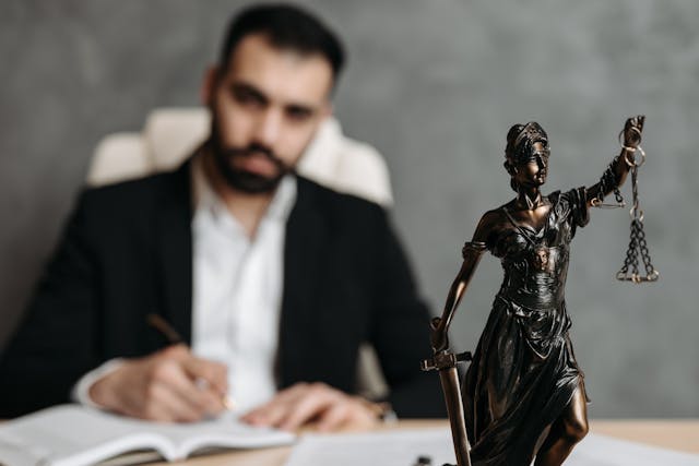 a lawyer with a small statue of Lady Justice on their desk